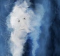 An elderly personÃ¢â¬â¢s face is seem as part of smoke rising upward